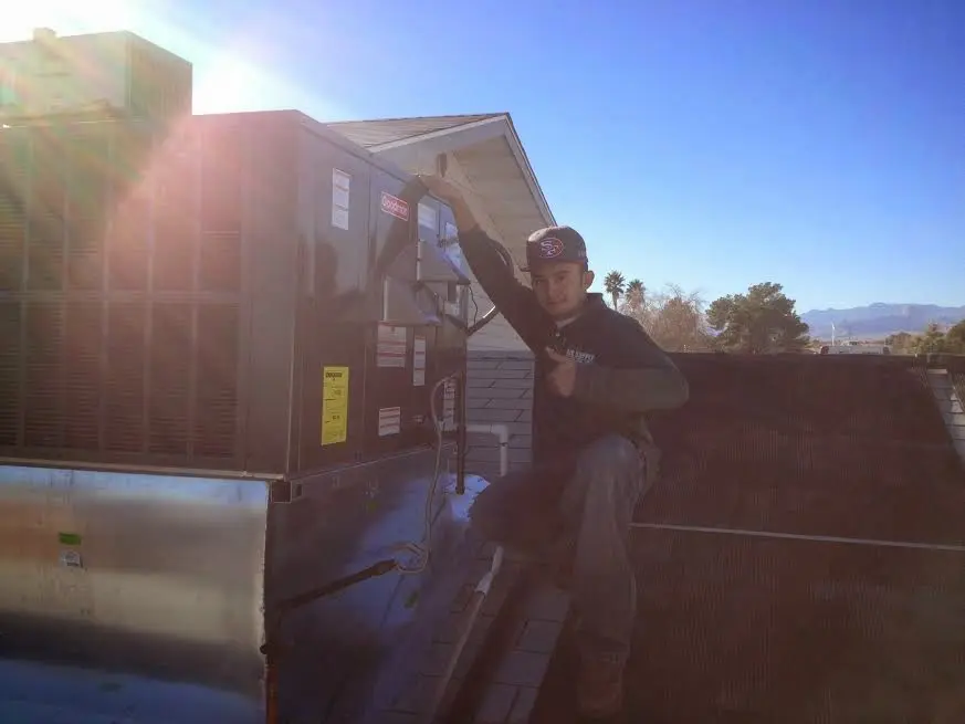 HVAC technician performing AC Tune-Up on a rooftop unit in Carol Stream